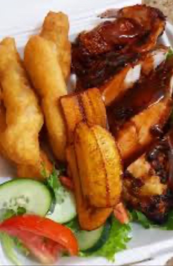 Jerk platter with festival, fried plantains, and fresh vegetables